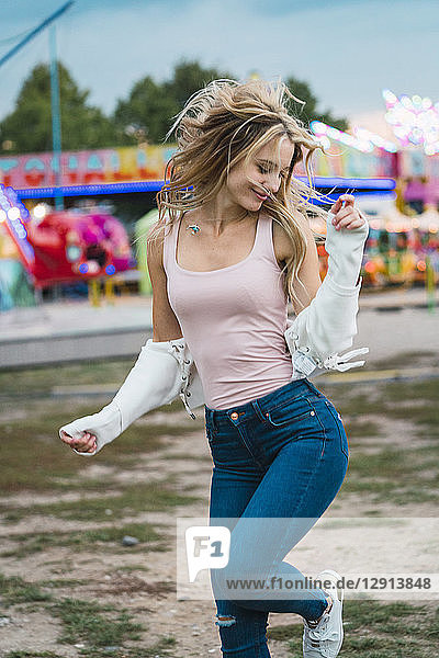 Happy young woman moving on a funfair
