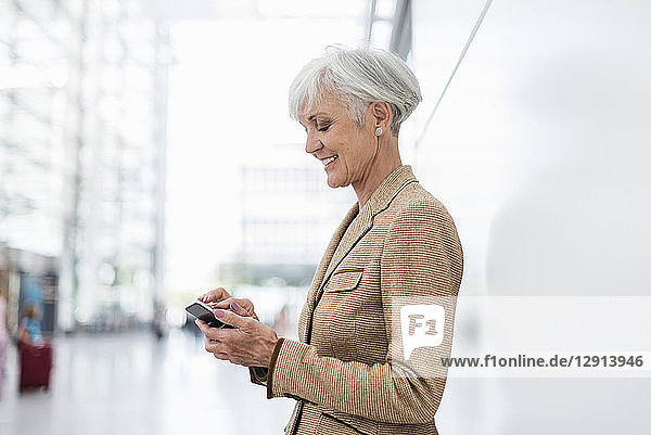 Smiling senior businesswoman using cell phone