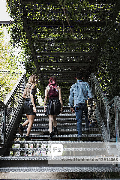 Friends with skateboard walking on stairs outdoors