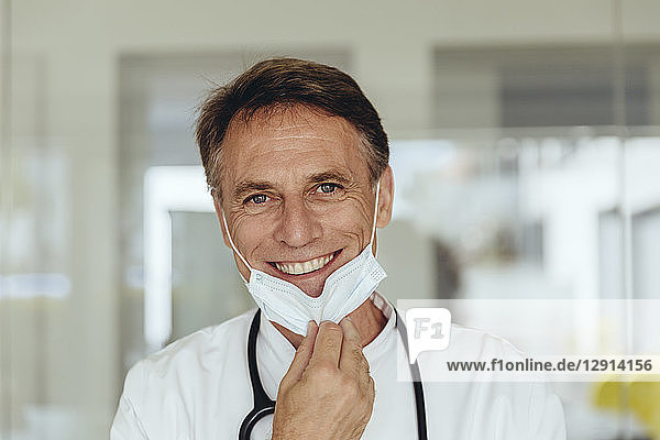 Portrait of a doctor  removing surgical mask  smiling