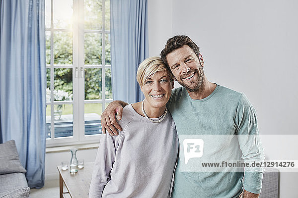 Portrait of happy couple embracing at home
