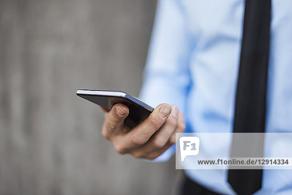 Close-up of businessman holding smartphone