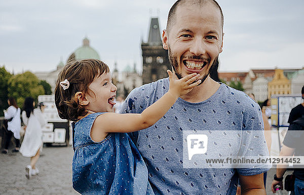 Czechia  Prague  father and little daughter having fun together on Charles Bridge