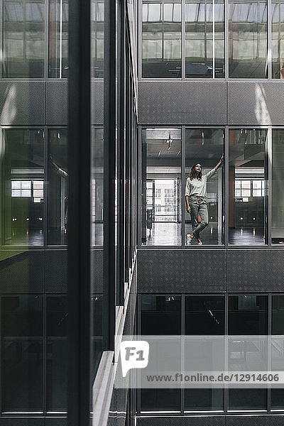 Woman standing at office window  looking up