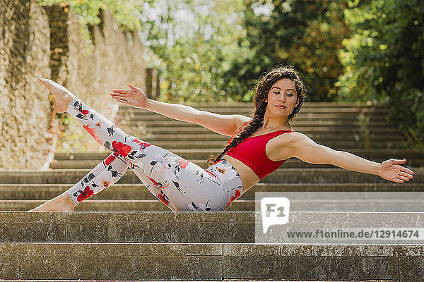 Young woman practicing Pilates in an urban park