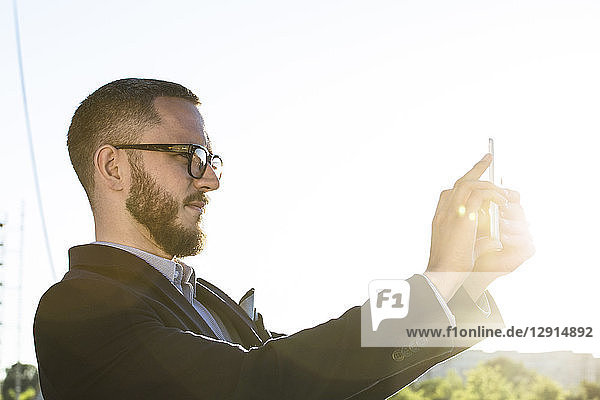 Businessman holding a tablet in backlight
