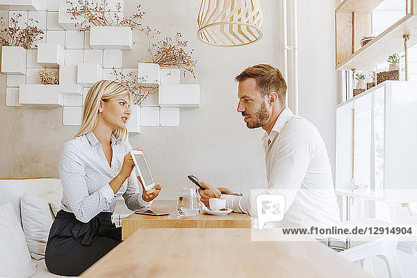 Businessman and businesswoman having a meeting in a cafe