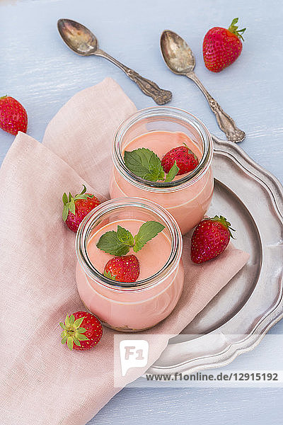 Two glasses of strawberry trifle with mascarpone cream and Amarettini