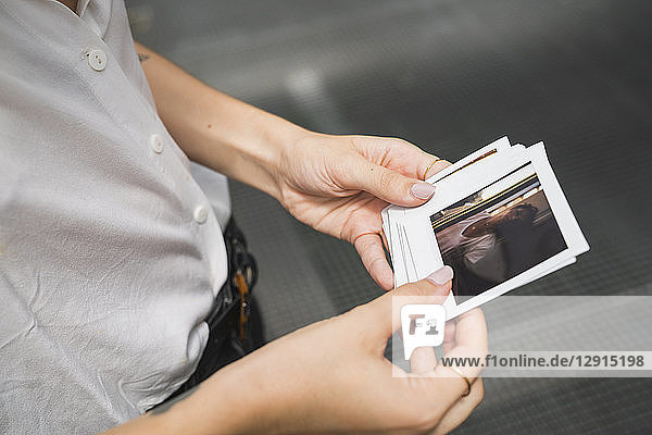 Young woman holding instant photos