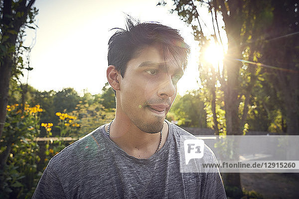 Portrait of a young man in a park at sunset