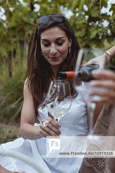 Woman pouring wine in glass on a picnic in nature