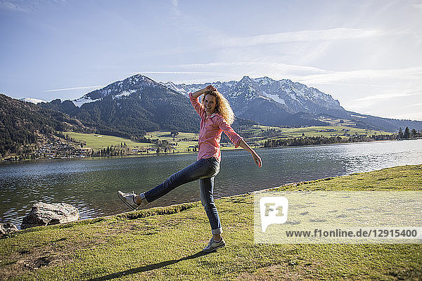 Austria  Tyrol  Walchsee  happy woman striding at the lake