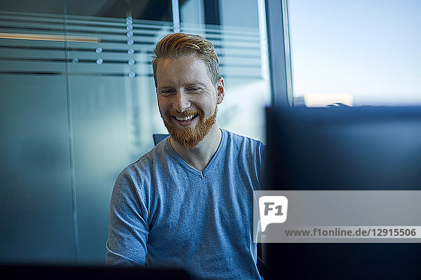 Happy businessman at desk in office
