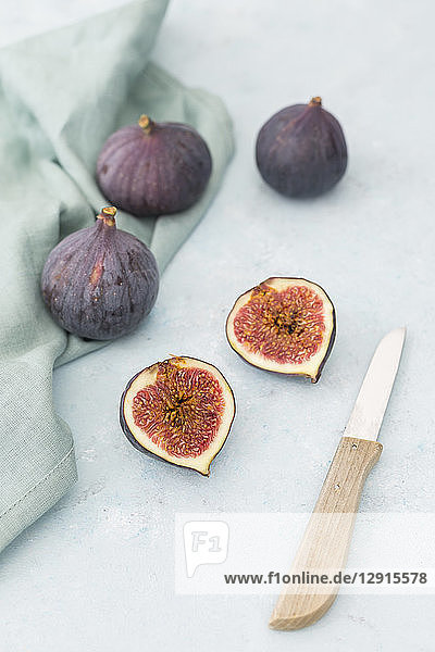 Sliced and whole fresh figs  kitchen knife and cloth