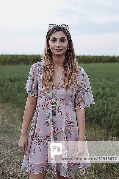 Woman standing in field  wearing summer dress