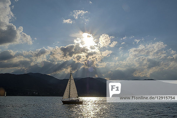Germany  Bavaria  Upper Bavaria  Tegernsee valley  lake Tegernsee  Bad Wiessee  Sailing boat at sunset  seen from peninsula Point