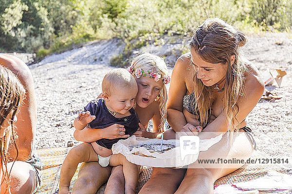 Family celebrating baby boy's first birthday at the riverside