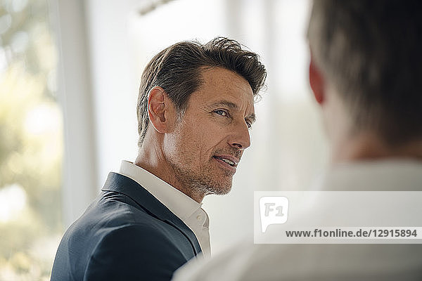 Mature businessman talking to colleague at a meeting