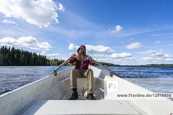 Finland  Man rowing in a boat on a lake