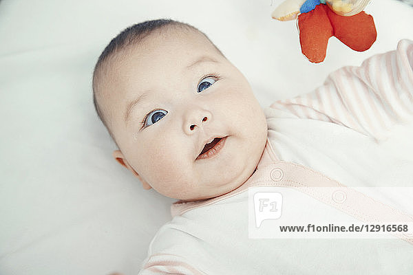 Smiling baby lying on bed  portrait
