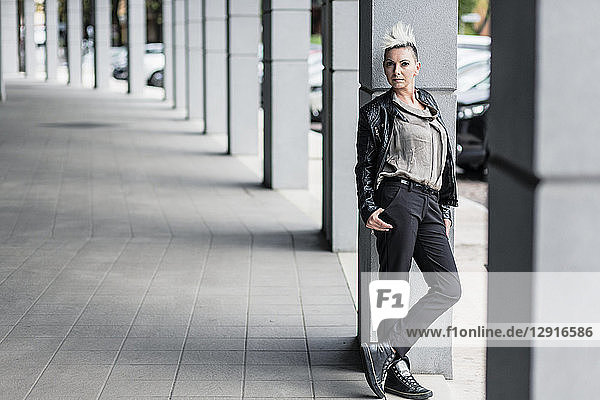 Portrait of punk woman leaning against a column