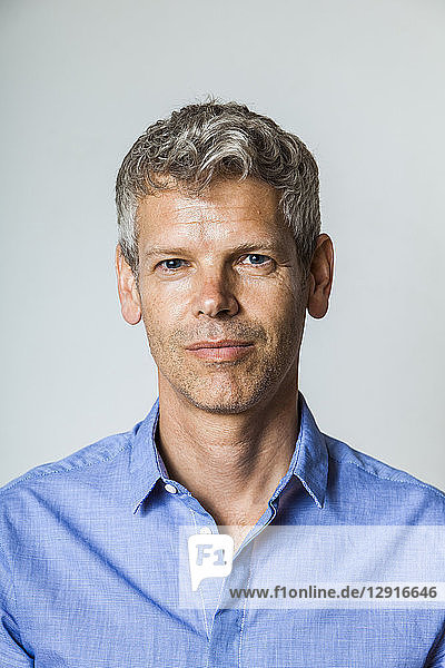 Portrait of mature man with grey hair wearing blue shirt