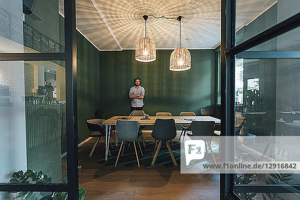 Man standing alone in office of his start up company  working long hours