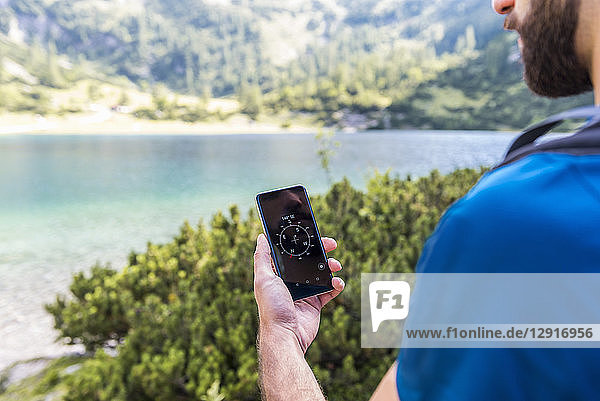 Austria  Tyrol  Hiker using compass app at Lake Seebensee