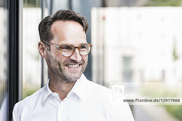 Portrait of smiling businessman with stubble wearing glasses