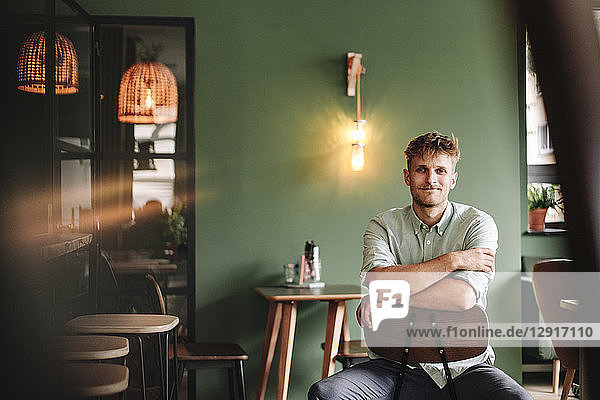 Young business owner sitting in his coffee shop