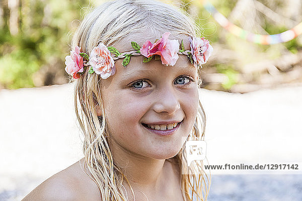 Portrait of smiling girl wearing flower crown outdoors in summer