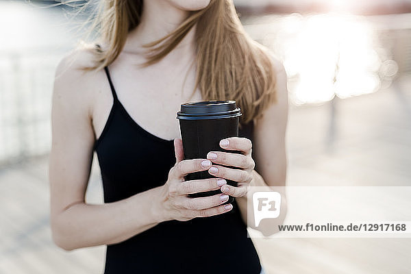 Young woman holding cup of coffee