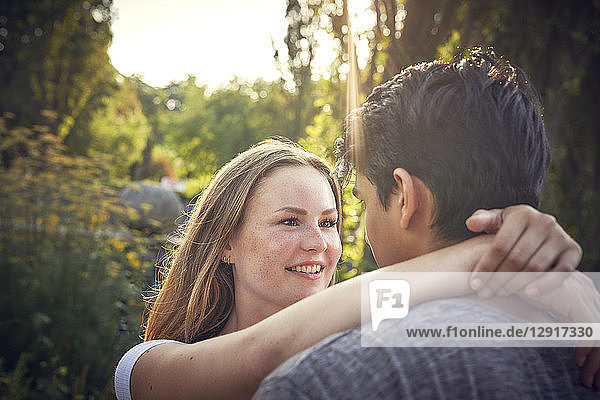 Happy young couple flirting in a park in summer