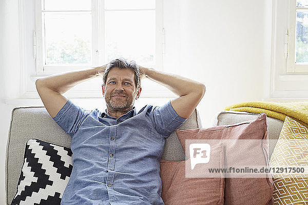Man sitting on couch at home  relaxing
