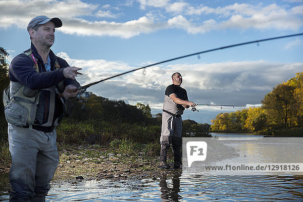 Two men fishing on riverbank of Grand River  Hamilton  Ontario  Canada