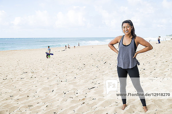 Strong young woman standing on sandy beach on North Shore of Oahu at daytime  Hawaii  USA