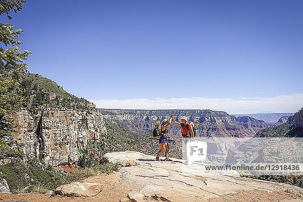 Zwei Wandererinnen geben sich die Hand  nachdem sie den steilen Aufstieg aus dem Grand Canyon geschafft haben  Arizona  USA