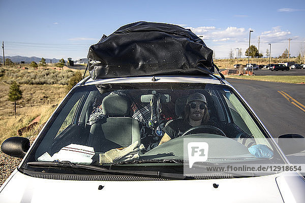 Vorderansicht eines Mannes  der im Auto sitzt  mit Gepäck auf dem Dach  Bryce Canyon National Park  Utah  USA
