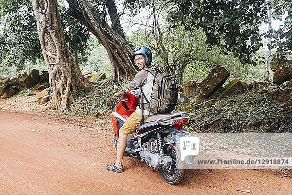 A tourist on a motorcycle looking at the camera  Siem Reap  Cambodia