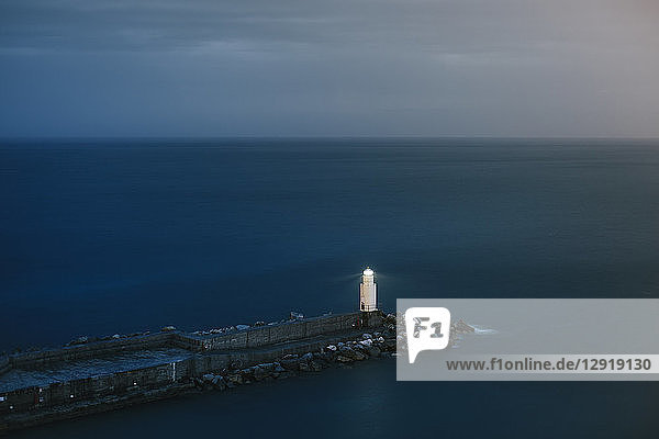 Ruhige Meereslandschaft mit einsamen Leuchtturm und Pier in der Abenddämmerung  Camogli  Ligurien  Italien