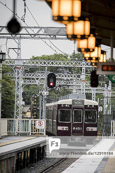 Zug  der vom Bahnhof abfährt  beleuchtet von leuchtenden Laternen  Arashiyama  Kyoto  Japan
