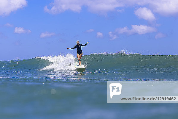 Clouds over female surfer riding wave  Male  Maldives
