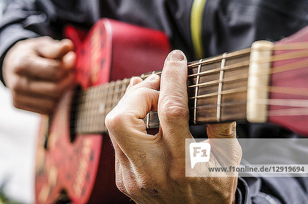Nahaufnahme der Hände eines Gitarre spielenden Mannes  Val di Mello  Val Masino  Italien
