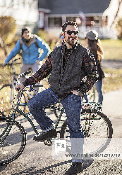 Portrait of bearded man wearing sunglasses standing with bicycle and smiling  Portland  Maine  USA