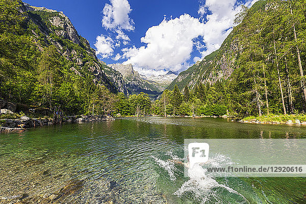 Ein Junge schwimmt in einem klaren Bergsee  Val di Mello (Mello-Tal)  Valmasino  Valtellina  Lombardei  Italien  Europa