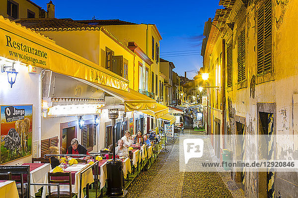 Blick auf Cafés in einer gepflasterten Straße in der Altstadt in der Abenddämmerung  Funchal  Madeira  Portugal