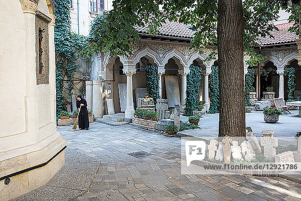 Eine Nonne fegt frühmorgens das Gelände der Stavropoleos-Klosterkirche (Biserica Manastirea Stavropoleos)  Bukarest  Rumänien