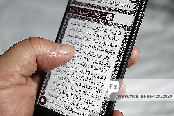 Mann liest einen elektronischen Koran auf einem Smartphone  Vietnam  Indochina  Südostasien