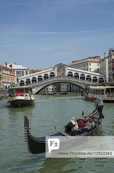 Wasserbus und Gondel auf dem Canal Grande mit der Rialto-Brücke im Hintergrund  Venedig  UNESCO-Weltkulturerbe  Venetien  Italien