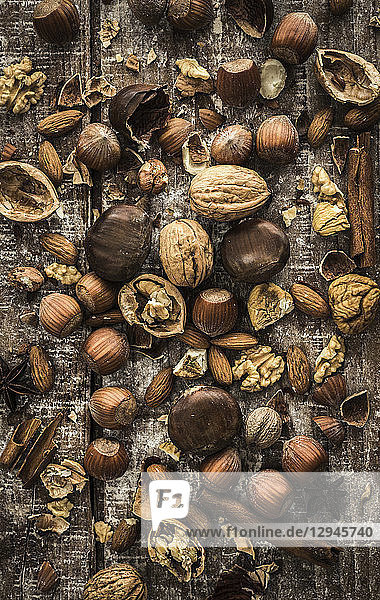 Verschiedene Nüsse  Zimtstangen und Sternanis auf einer Holzunterlage